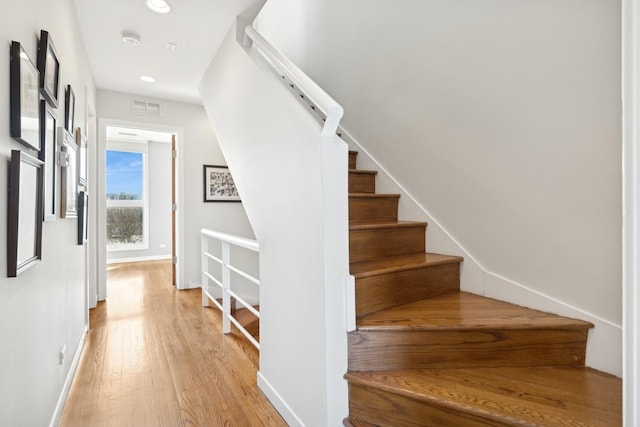 stairway featuring recessed lighting, visible vents, baseboards, and wood finished floors