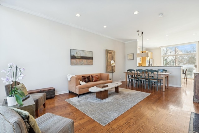 living room with recessed lighting, crown molding, baseboards, and wood finished floors