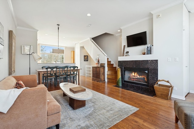 living room with a fireplace, crown molding, recessed lighting, wood finished floors, and baseboards