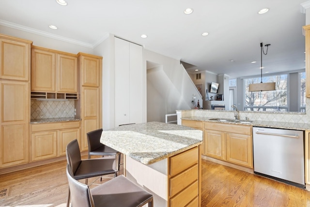 kitchen featuring dishwasher, light brown cabinetry, a sink, and light wood-style floors