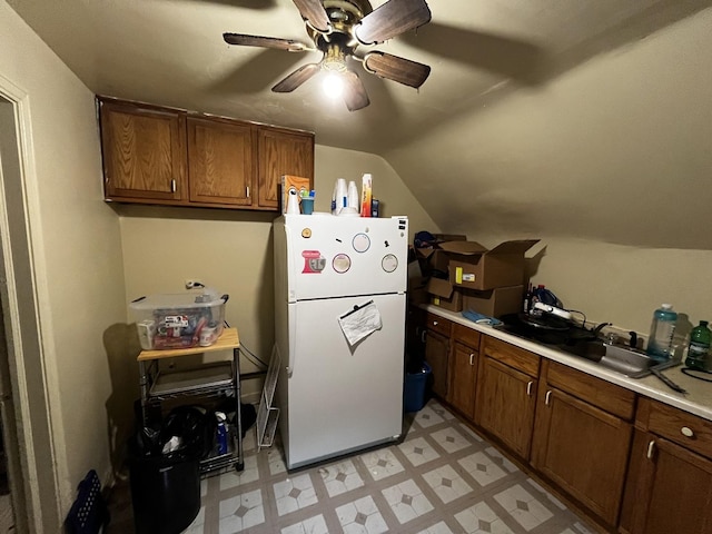 kitchen featuring ceiling fan, sink, vaulted ceiling, and white fridge