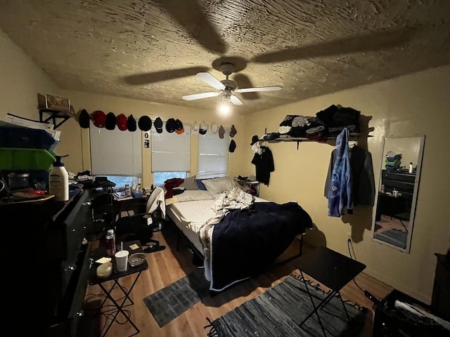 bedroom featuring wood-type flooring, a textured ceiling, and ceiling fan