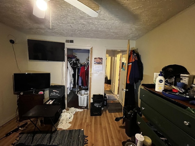 bedroom with hardwood / wood-style floors, a closet, and a textured ceiling