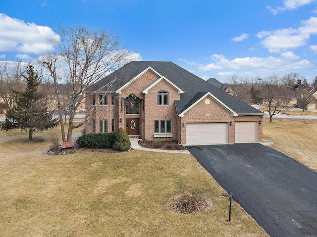 view of front of house with driveway, a garage, roof with shingles, a front yard, and brick siding