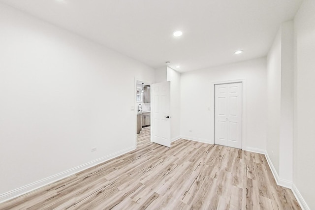 empty room featuring sink and light hardwood / wood-style floors