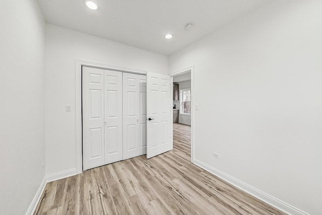 unfurnished bedroom with a closet and light hardwood / wood-style flooring