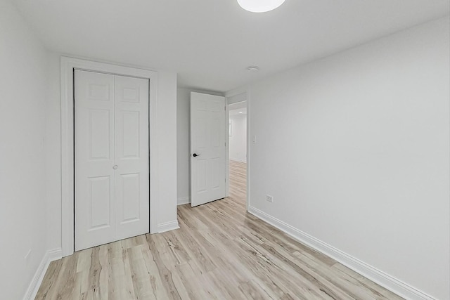 unfurnished bedroom featuring a closet and light wood-type flooring