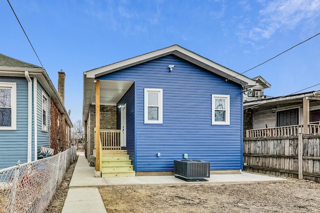 rear view of property with central AC