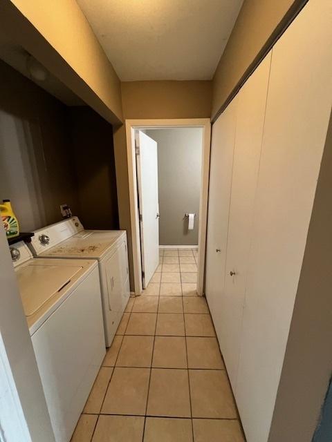 clothes washing area featuring light tile patterned flooring and separate washer and dryer