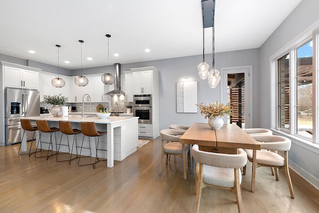 kitchen featuring white cabinetry, appliances with stainless steel finishes, and hanging light fixtures