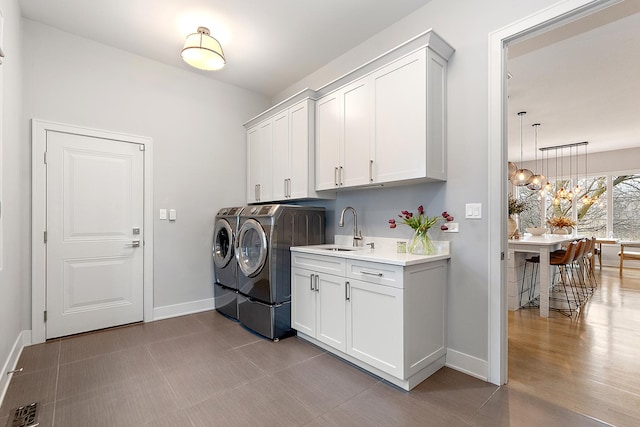 washroom featuring cabinets, sink, and washer and dryer