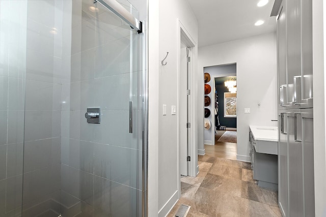 bathroom featuring walk in shower and vanity