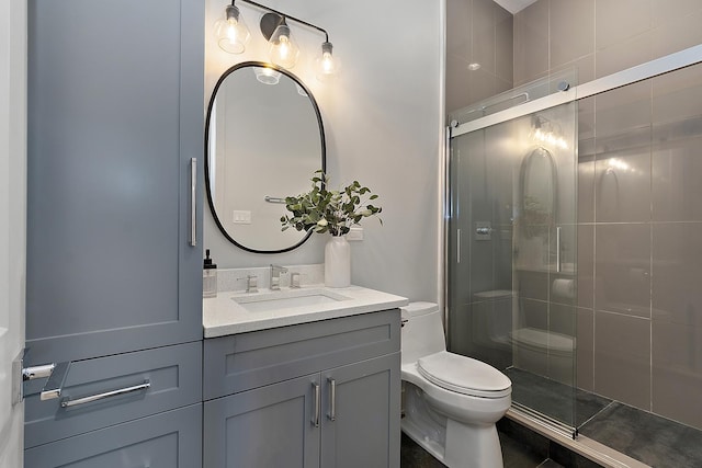 bathroom with vanity, toilet, and a shower with door