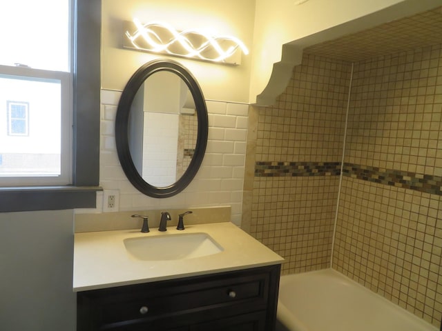 bathroom featuring vanity, tile walls, and a bathing tub