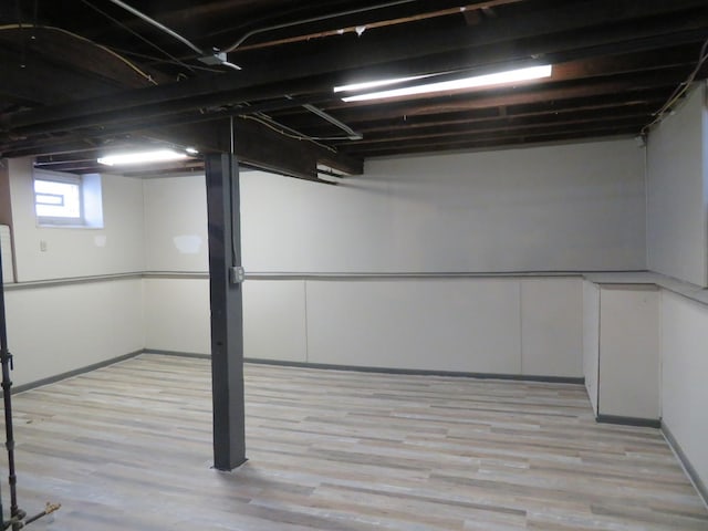 basement with light hardwood / wood-style flooring