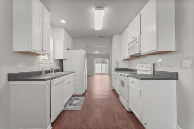 kitchen featuring white cabinetry, white appliances, dark hardwood / wood-style flooring, and sink