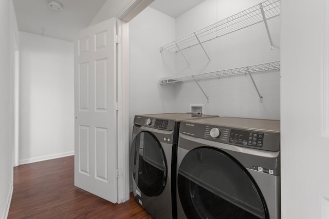 washroom with dark wood-type flooring and washing machine and dryer