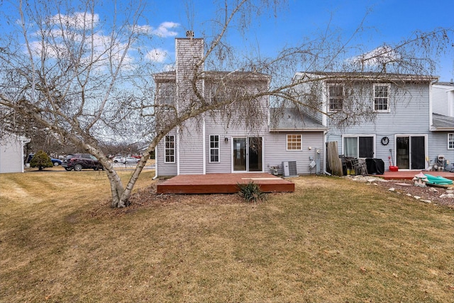 rear view of property featuring a yard and a deck