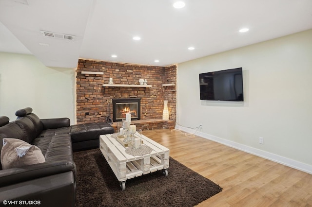 living room with hardwood / wood-style flooring and a brick fireplace