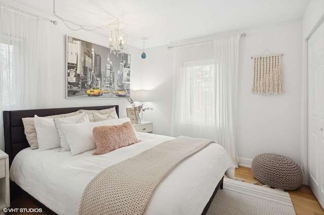 bedroom featuring an inviting chandelier and hardwood / wood-style floors