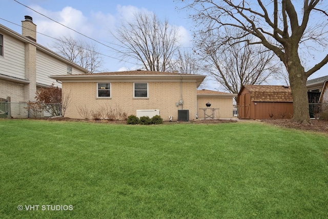 rear view of property with a yard and cooling unit