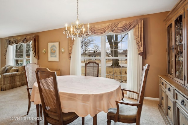 dining space featuring light colored carpet and a notable chandelier