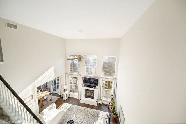 living room with a towering ceiling and dark wood-type flooring