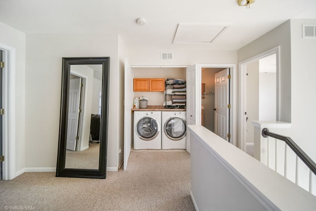 clothes washing area with light carpet, cabinets, and washing machine and clothes dryer