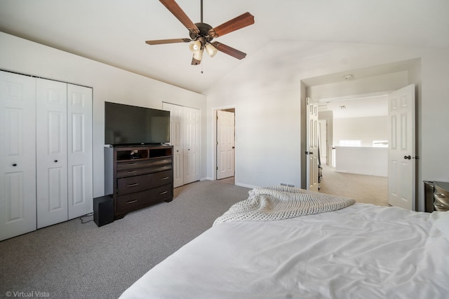 bedroom with light carpet, two closets, lofted ceiling, and ceiling fan