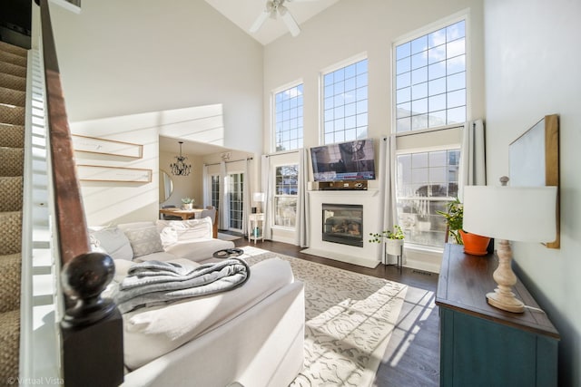 living room featuring dark wood-type flooring, plenty of natural light, high vaulted ceiling, and ceiling fan