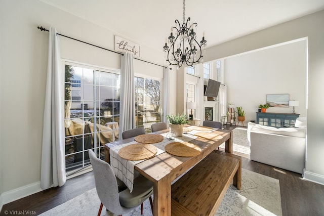 dining space with an inviting chandelier and dark hardwood / wood-style flooring