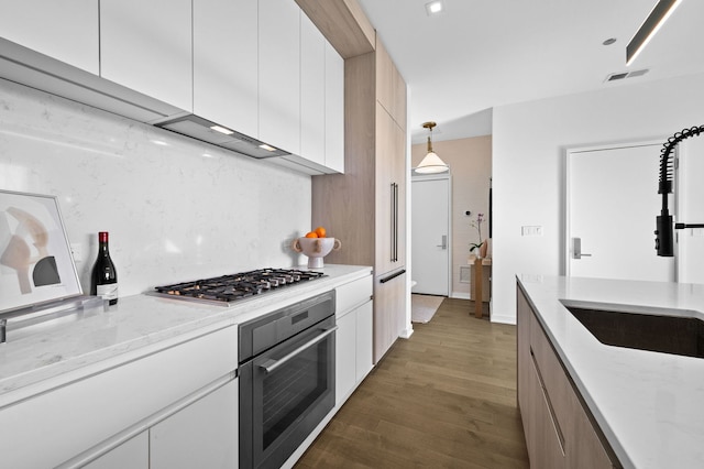 kitchen featuring wall oven, visible vents, white cabinets, dark wood-style floors, and stainless steel gas cooktop