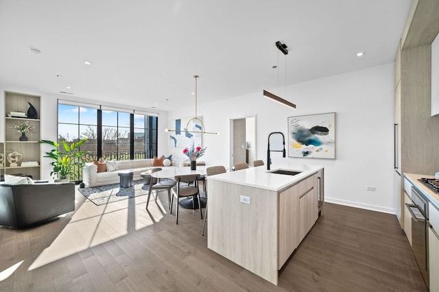 kitchen featuring dark wood-style flooring, light brown cabinets, a sink, and modern cabinets