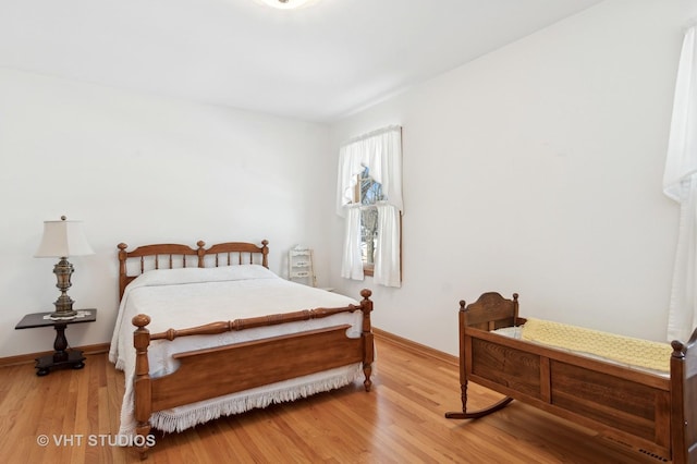 bedroom with baseboards and wood finished floors