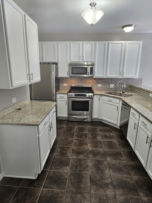 kitchen featuring stainless steel appliances, backsplash, a sink, and white cabinets