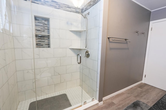 full bath with a shower stall, baseboards, and wood finished floors