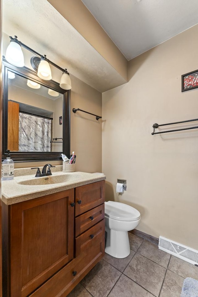 bathroom featuring vanity, tile patterned flooring, and toilet