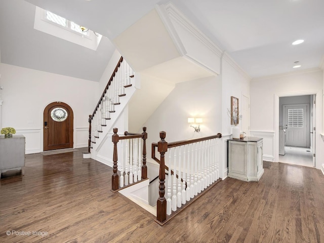 corridor with crown molding, dark hardwood / wood-style flooring, and a skylight