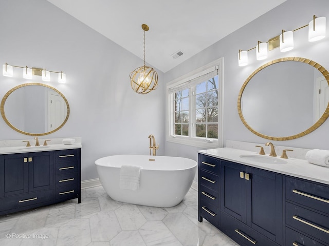 bathroom featuring an inviting chandelier, lofted ceiling, a tub to relax in, and vanity