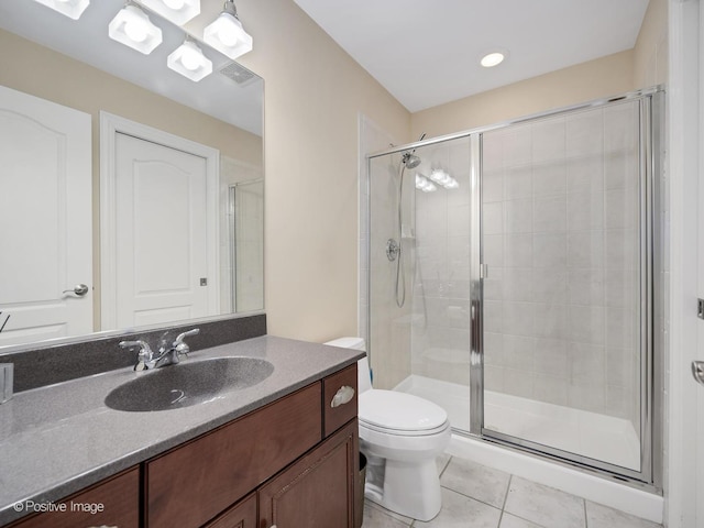 bathroom featuring vanity, tile patterned floors, a shower with door, and toilet