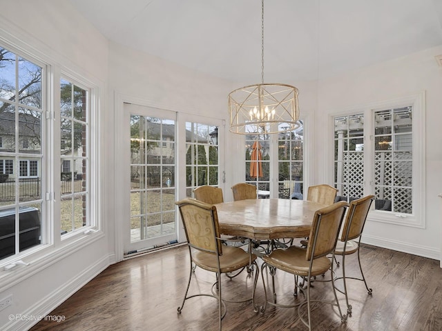 dining area featuring dark wood-type flooring, a wealth of natural light, and a chandelier