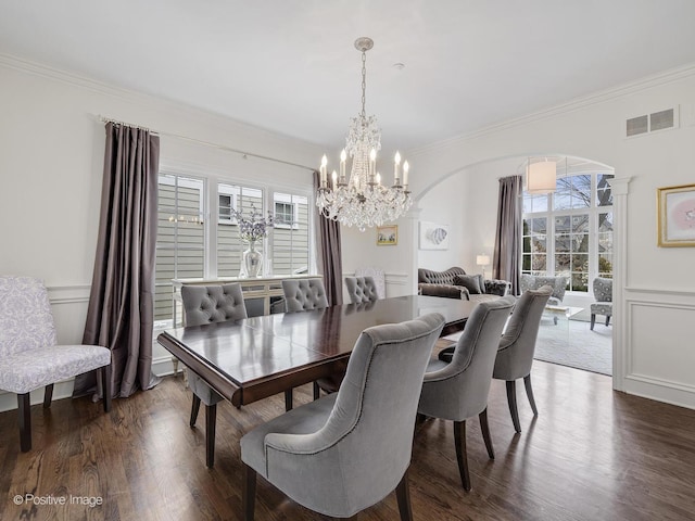 dining space featuring ornate columns, crown molding, and dark wood-type flooring