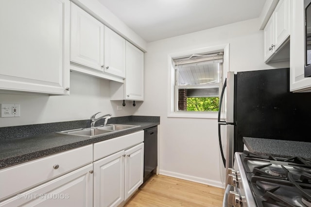 kitchen with stainless steel range with gas stovetop, a sink, dishwasher, white cabinets, and light wood-type flooring