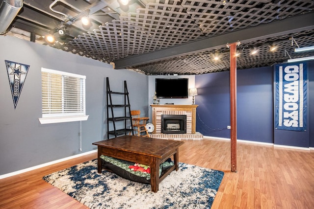 living room featuring a brick fireplace and hardwood / wood-style flooring