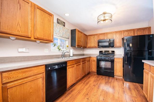 kitchen with light wood-type flooring, sink, and black appliances