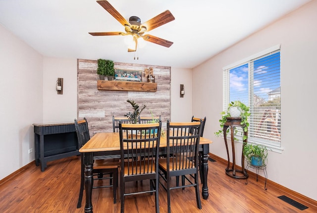 dining area with ceiling fan and hardwood / wood-style floors