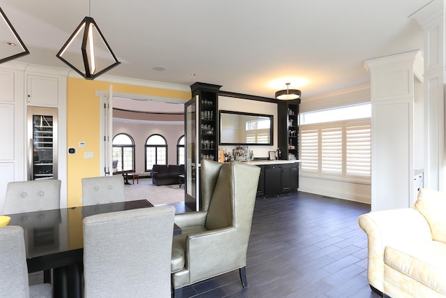 dining area with crown molding and dark wood-type flooring