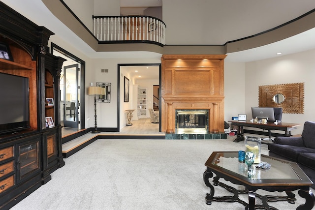 living room with a fireplace, light carpet, and a high ceiling