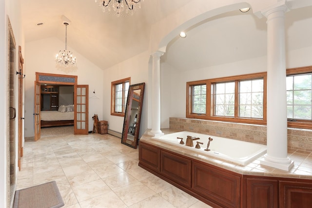 bathroom with ornate columns, lofted ceiling, a washtub, and a chandelier