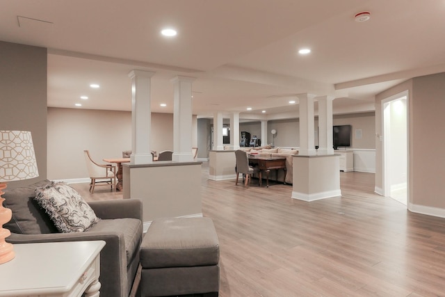 living room with light hardwood / wood-style flooring and ornate columns